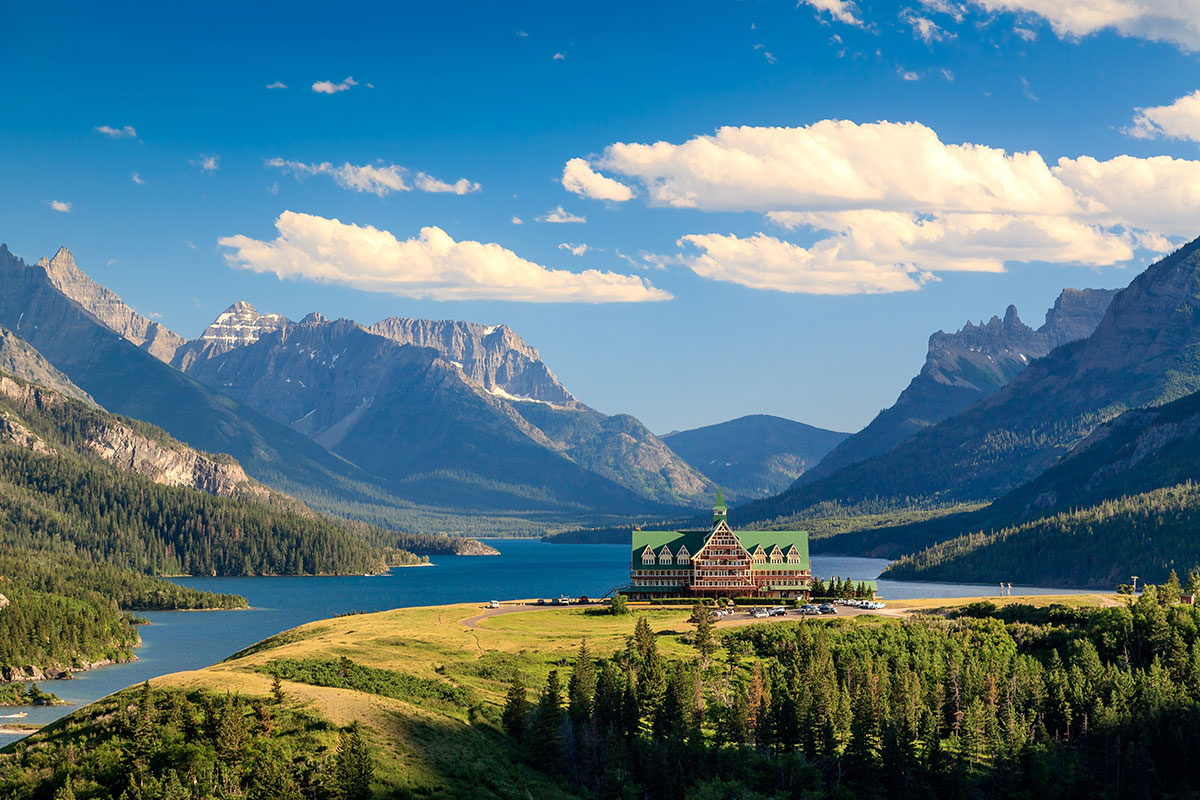 The lodge at Glacier National Park sits in front of the lake and mountains in the distance
